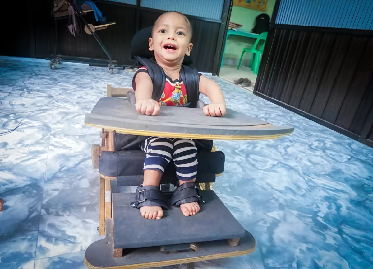 A child supported in a custom-built seating device