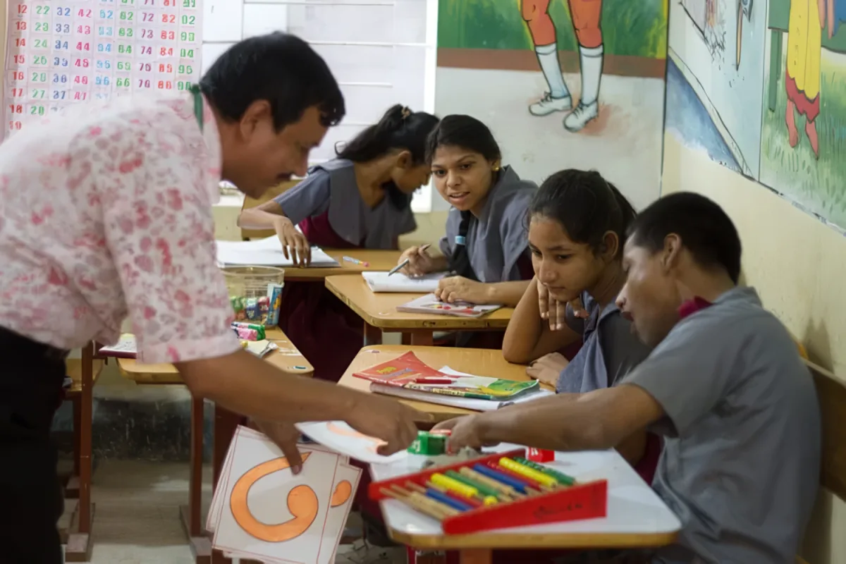 A teacher working with students at CRP inclusive school